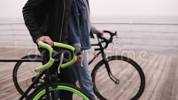 美丽的微笑的一对年轻的嬉皮士在秋日和他们的自行车一起拥抱在海边青年视频的预览图