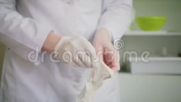 特写镜头显示医生双手她戴着白色一次性手套视频的预览图
