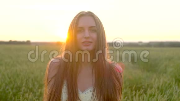 在夕阳西下的夏天美丽的女人穿着礼服在麦田上抛着金色的闪光纸屑美容视频的预览图