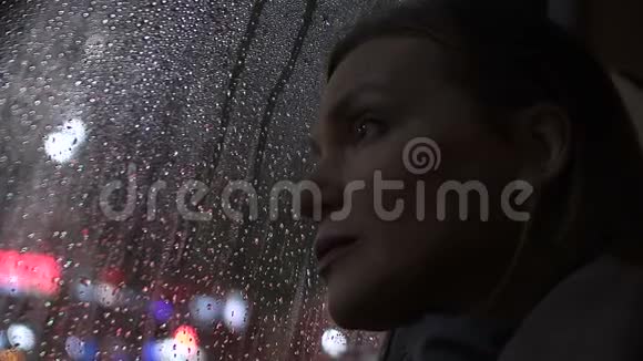 伤心的女人透过雨窗坐着出租车秋天的忧郁视频的预览图