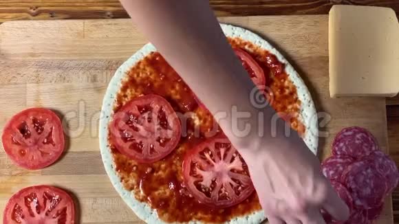 做披萨手工厨师把腊肠片放在面团上视频的预览图