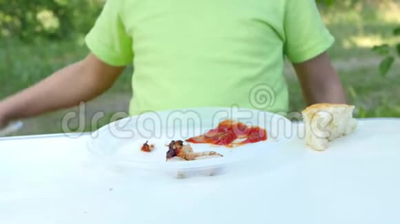 特写一个白色塑料板与石串在自然背景孩子吃烤串全家游客视频的预览图
