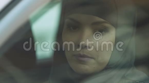 穆斯林妇女摇着车窗去检查道路细心的司机特写视频的预览图