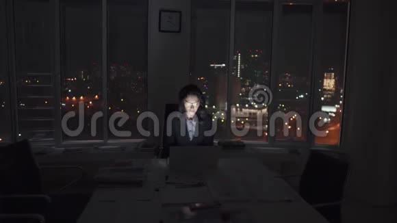 经理在办公室工作到很晚一位年轻的女企业家深夜靠灯光在笔记本电脑上工作视频的预览图