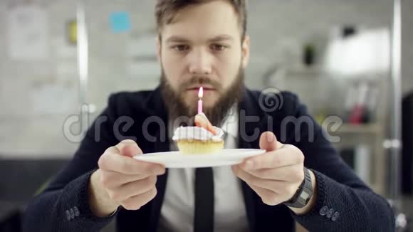 悲伤的工作胡子商人办公室工作人员正在办公室里庆祝一个孤独的生日他正在吹蜡烛视频的预览图