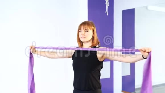 强壮的年轻女子正在做身体锻炼以发展手部背部和腹部肌肉视频的预览图