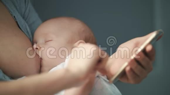 使用手机哺乳的母亲母乳妈妈在智能手机上工作视频的预览图