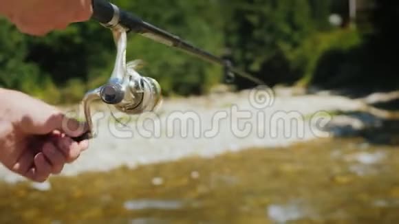 在一条小河上钓鱼渔人用钓竿钓鱼视频的预览图