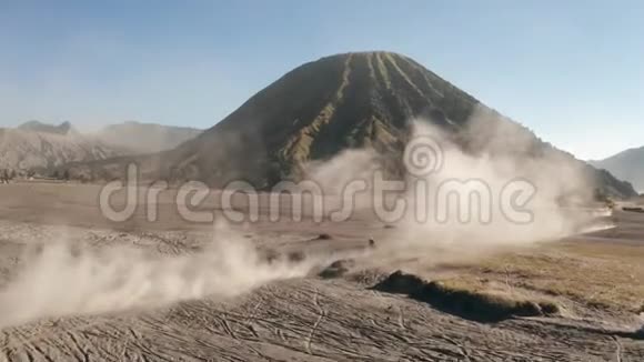 东爪哇美丽的Bromo山附近一个火山灰沙漠中驾驶摩托车越野车的鸟瞰图视频的预览图