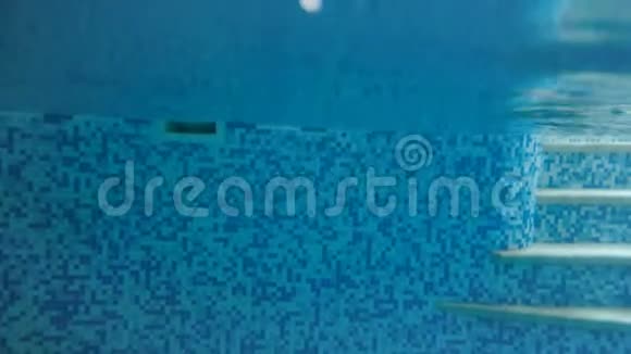 青少年女孩在游泳池水下潜水的4K视频从水面下看视频的预览图
