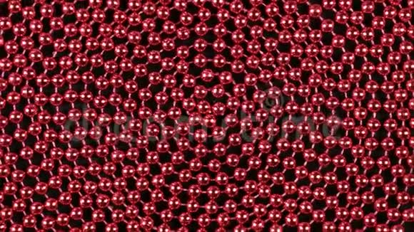 旋转一个螺旋状的红色珠子躺在黑色的布上视频的预览图