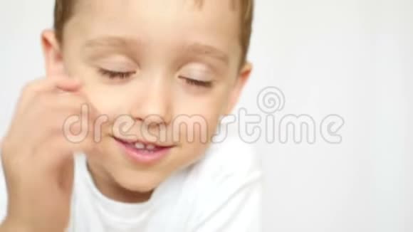 一个微笑的男孩的肖像然后是一个体贴的男孩孩子的脸贴在白色的背景上视频的预览图