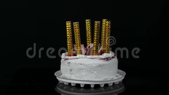 女人的手在一个漂亮的时尚的甜的新鲜的白色蛋糕上点着蜡烛蛋糕上点缀着樱桃酱奶油和视频的预览图