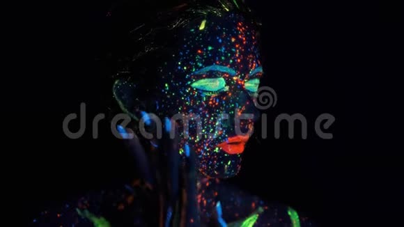 在霓虹灯下美丽的布鲁奈特女人的特写在黑暗的油漆中涂上了辉光视频的预览图