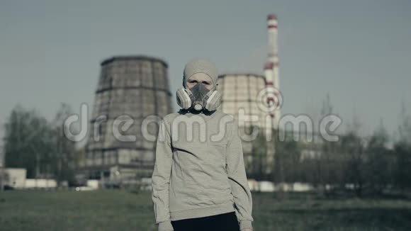 戴着污染面具的小男孩对着工厂的烟囱空气污染概念戴着灰色杯子和呼吸器的孩子视频的预览图