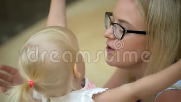 美丽的母亲和她的小女儿在室内亲吻和拥抱幸福的家庭母亲节快乐快乐妈妈和宝贝视频的预览图