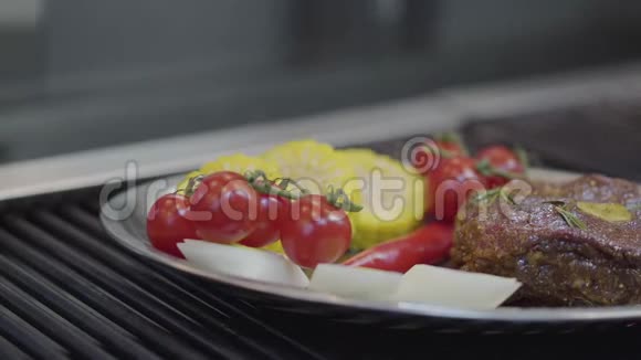 盘子里放着肉玉米樱桃番茄柠檬草和辣椒放在烤架上食物视频的预览图