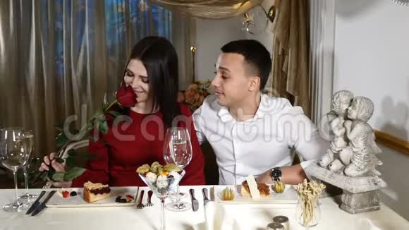 浪漫关系的概念在餐馆约会的情侣手中玫瑰浪漫的约会2月14概念穿红衣服的女人视频的预览图