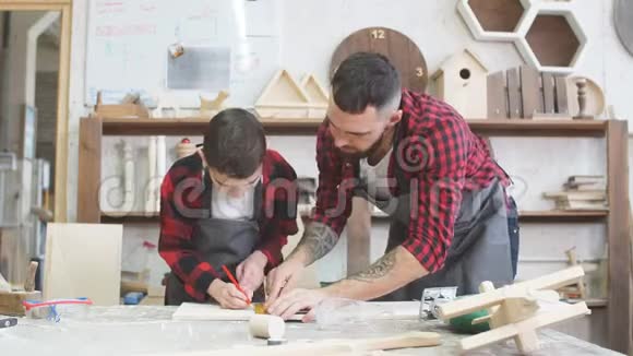 父亲和小儿子在参观木工大师班时给了高五视频的预览图