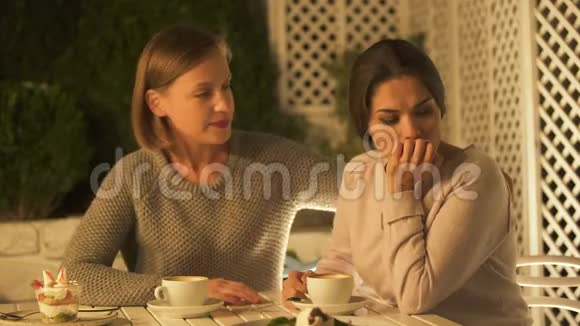 年轻的女士安慰和拥抱她沮丧的朋友在露台上喝咖啡视频的预览图