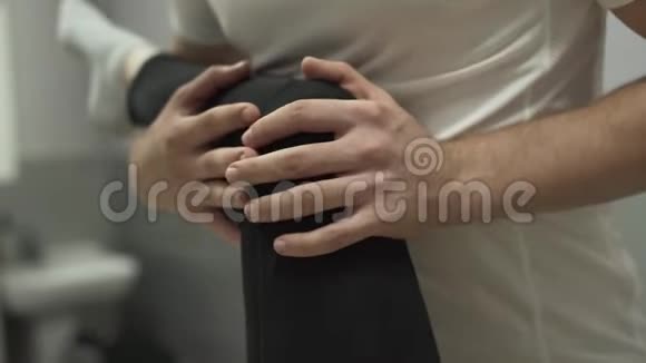 躺在按摩台上的年轻女子的男性手部按摩膝盖的特写按摩治疗师的女孩视频的预览图