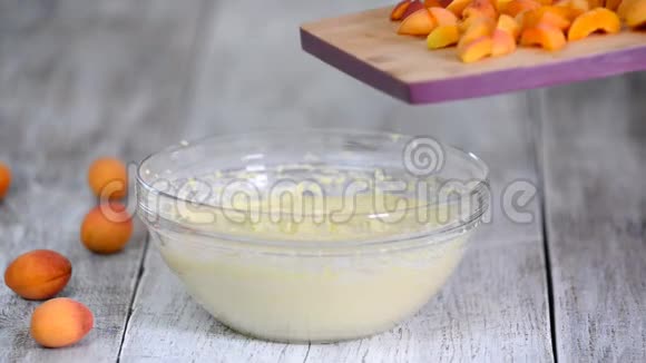 厨师在蛋糕面糊中加入杏子手把杏和面糊混合在一起做杏子蛋糕视频的预览图