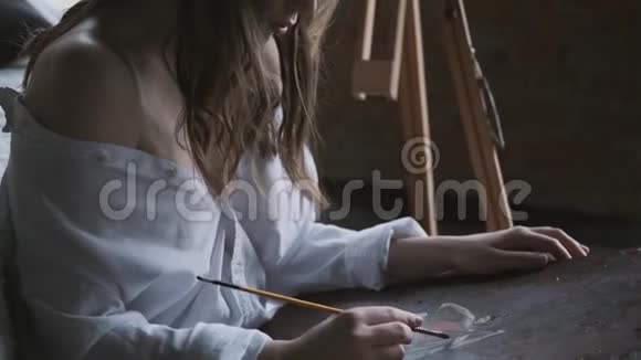 艺术家的特写肖像女孩画了一幅坐在地板上的画视频的预览图