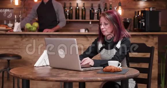 对咖啡店里用智能手机付钱的女人放大镜头视频的预览图