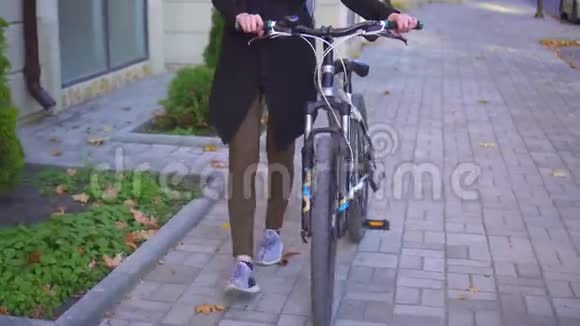 穆斯林妇女戴着头巾背着一个自行车背包穿过一个阳光明媚的秋天城市视频的预览图