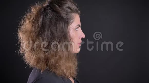 超重的高加索女人的特写镜头转向镜头在黑色背景下平静地看着镜头视频的预览图