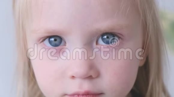 一个害羞美丽的金发大眼睛小女孩的肖像视频的预览图