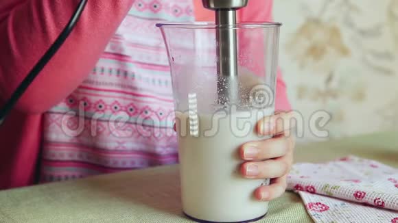 女人用搅拌机用牛奶和香蕉做牛奶鸡尾酒视频的预览图