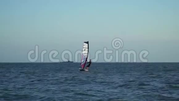 熟练的水上运动员在海角里骑着风车喜欢水上运动的人在阳光下骑着风翼视频的预览图