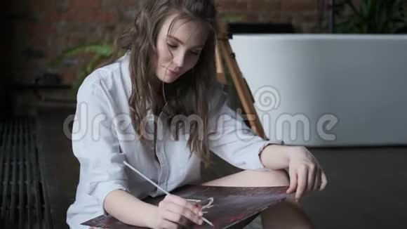 一位迷人的女画家在轻松的气氛中工作的肖像艺术家在家里的工作室里画了一幅画视频的预览图
