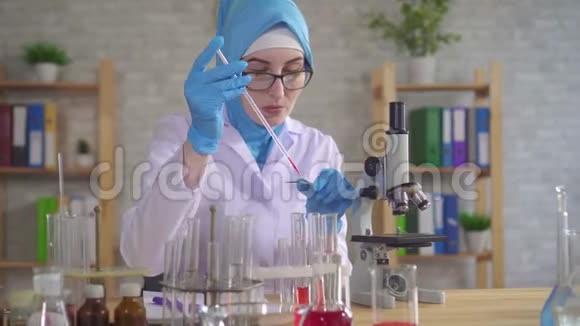 在实验室工作的国家围巾的穆斯林女科学家化学家视频的预览图