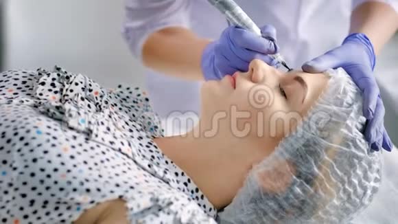 美容师用纹身笔机为美容院的眉毛做永久性化妆视频的预览图