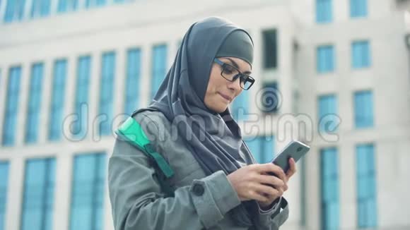 开朗的穆斯林学生在电话聊天写邮件自由交流视频的预览图