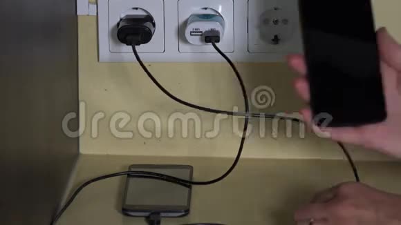 女性手把智能手机挂在墙上充电器上视频的预览图