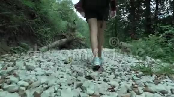 年轻可爱的女孩转身微笑在夏天的森林里从鞋子里走过白色的鹅卵石小径视频的预览图