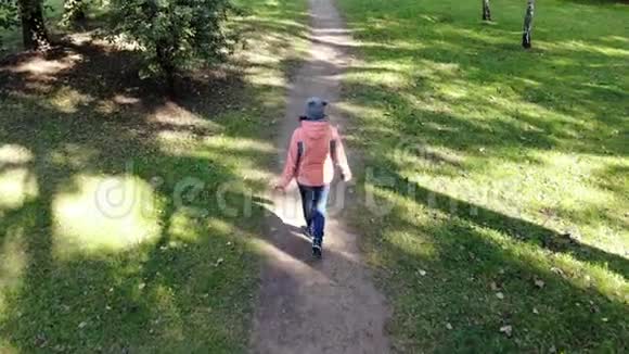 秋天公园里一位年轻的美女在树上散步空中拍摄无人机的视频视频的预览图