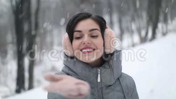 快乐的女孩在森林中的手中感受雪视频的预览图
