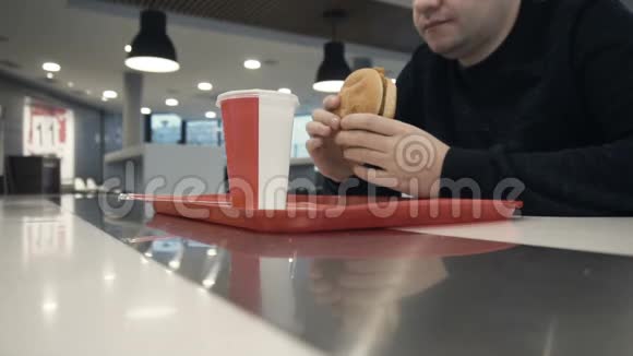 男人在慢吞吞地吃汉堡包或奶酪汉堡之前舌头舔嘴视频的预览图