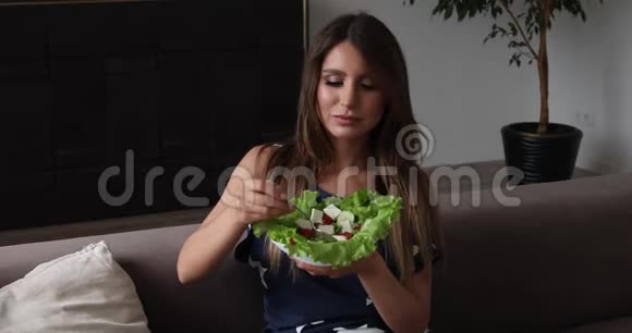 美丽的微笑女人吃开胃的沙拉制作空气吻中镜头的肖像视频的预览图