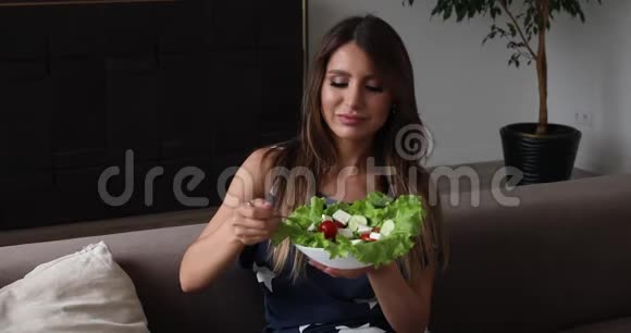 美丽的微笑女人吃开胃的沙拉制作空气吻中镜头的肖像视频的预览图