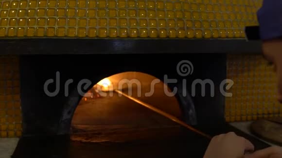 慢动作厨师用金属铁铲将火点到木石炉视频的预览图
