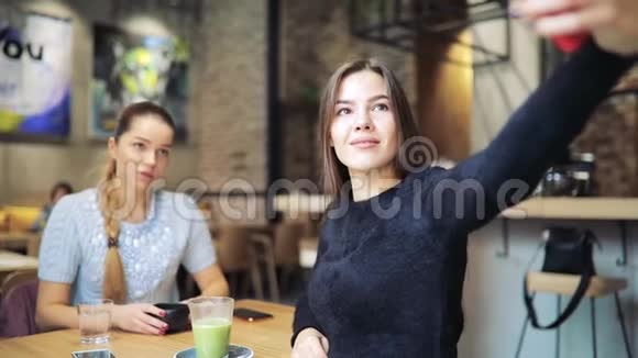 女朋友在咖啡馆里拍手机自拍视频的预览图