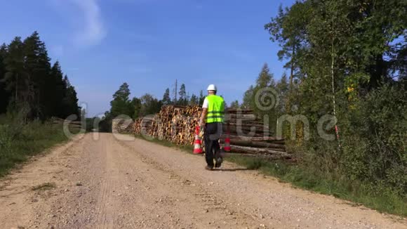 林业工人在靠近木桩的农村公路上放置路锥视频的预览图