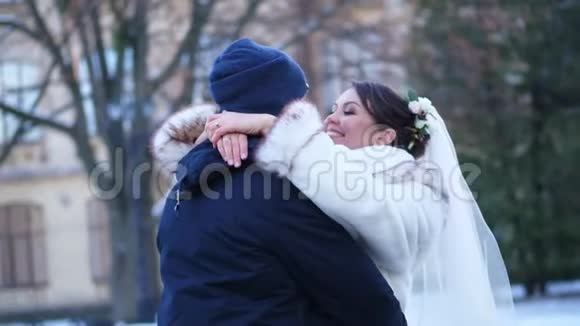 冬季婚礼新婚夫妇穿着婚纱新婚之吻拥抱情人的浪漫之吻他们很高兴视频的预览图