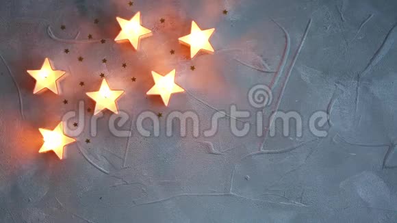 圣诞装饰明星蜡烛在灰色纹理背景下发光视频的预览图