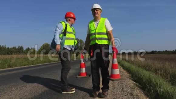 公路上两名筑路工人视频的预览图